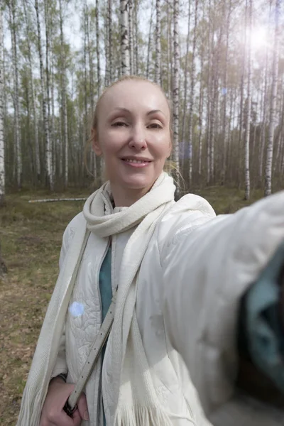 Egy Fehér Kabát Egy Nyírfa Erdő Mosolyog Selfi — Stock Fotó