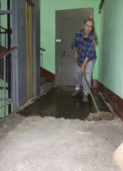 cleaning woman doing wet cleaning on the landing of an apartment building