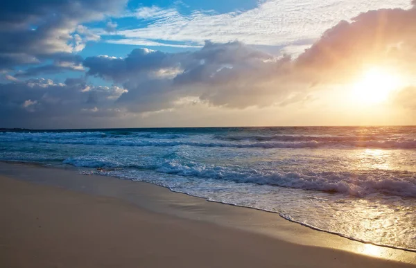海に沈む夕日と砂浜での波の泡が — ストック写真