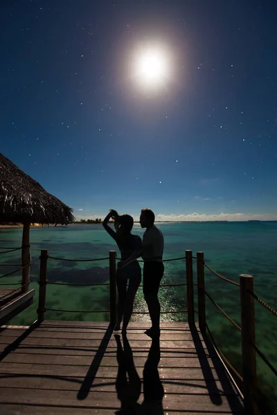 星空の下で夜の海の端で恋に落ちるカップルのシルエット — ストック写真