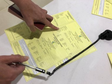 BALI, DENPASAR- 28 Mart 2020: insanlar havaalanına vardıklarında sağlık uyarısı kartı doldururlar
