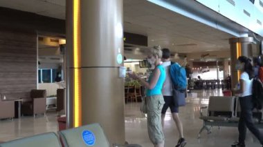 INDONEZYA, ISLAND LOMBOK-MARCH 28 Mart 2020: Bir Coronavirus salgını sırasında arka plandaki boş koltukların dezenfektanlarıyla ellerini yıkadı