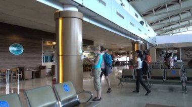 INDONEZYA, ISLAND LOMBOK-MARCH 28 Mart 2020: Bir Coronavirus salgını sırasında arka plandaki boş koltukların dezenfektanlarıyla ellerini yıkadı