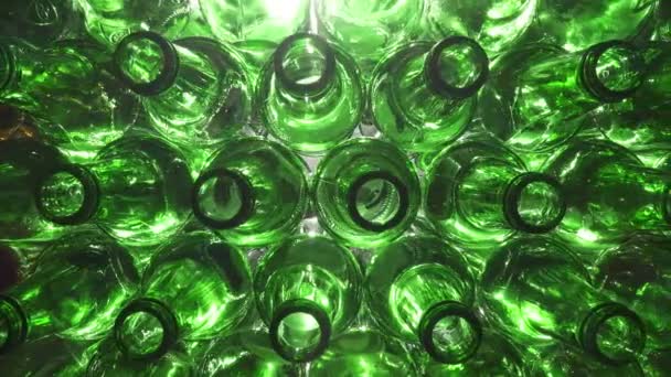 白い背景に積み上げられた緑のガラスボトルの上部または開口部のドーリーショットを閉じます。 4K UHDで撮影 — ストック動画
