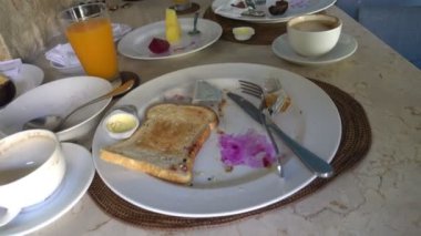 Bir sürü kirli bulaşık ve arta kalan yemekler. Yemek artıklarıyla kirli bulaşıklar, kahvaltıdan sonra tabakta yemekler, 4K UHD 'de çekim.