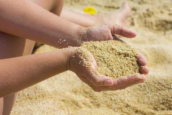 Zand in de handen van de vrouw — Stockfoto