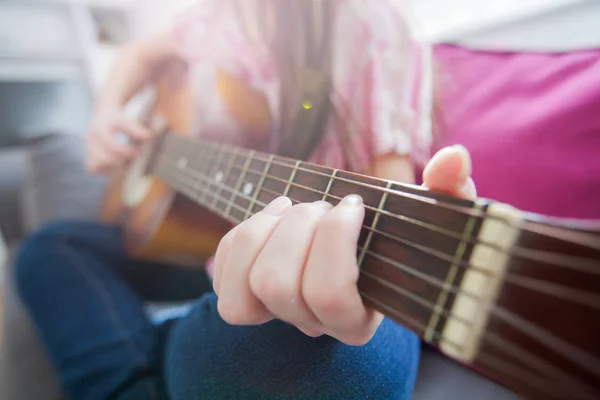 Main féminine jouant de la guitare acoustique — Photo