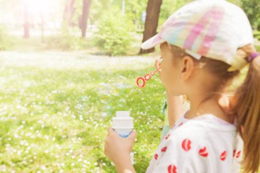 Küçük kız yaz park, yeşil alanlar, doğa arka plan, Bahar sezonu sabun köpüğü üfleme 