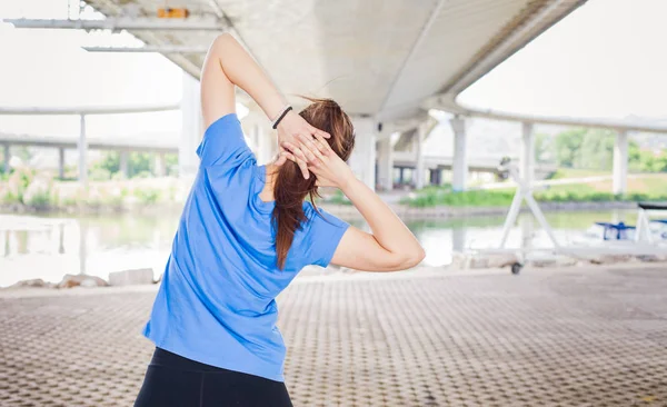 年轻的运动妇女做伸展运动前硬锻炼外 — 图库照片
