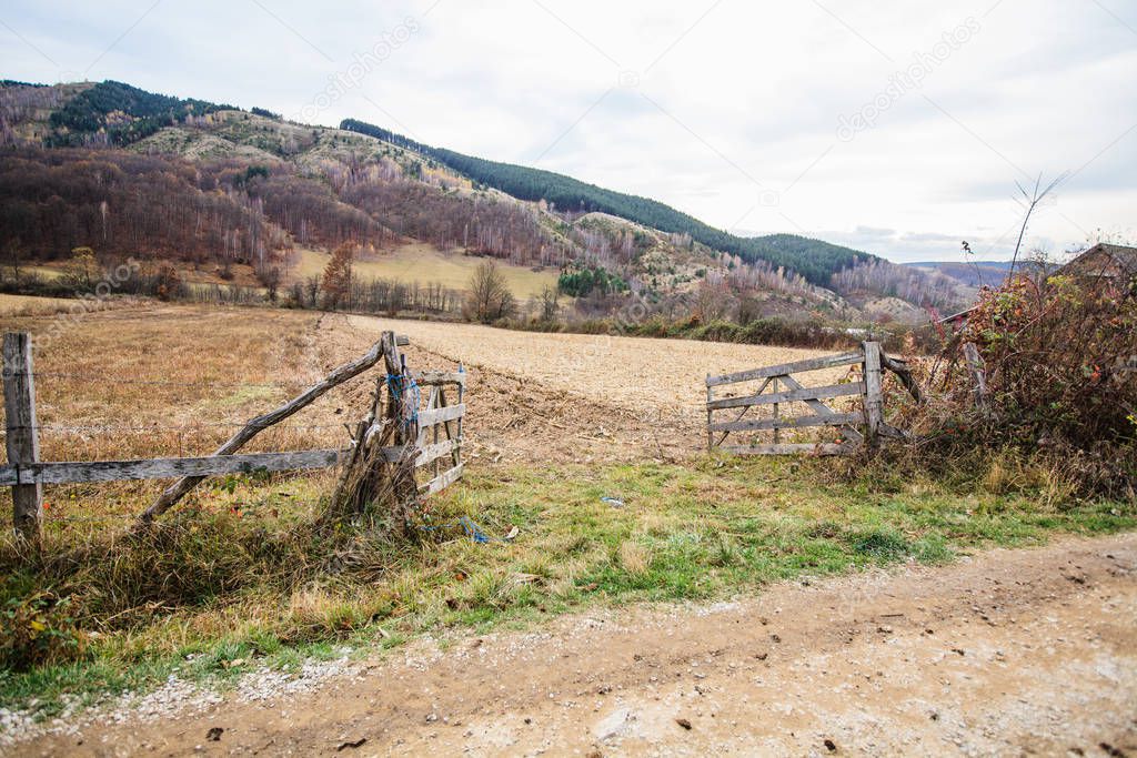 Wooden fence at farmland, autumn season, rural landscape 