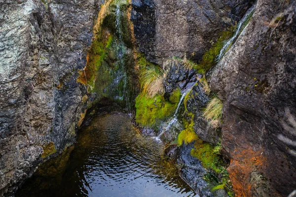 Chute d'eau qui coule à travers de grandes roches — Photo