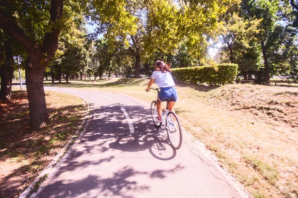 Mulher bonita se divertindo andando de bicicleta na natureza — Fotografia de Stock