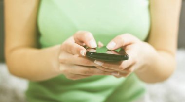 Telefonu kullanarak kadın ellerini kapatın. Akıllı telefonda yazan tanınmayan kişi.