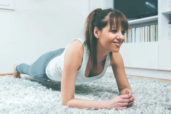 健康的年轻女人在家里锻炼 健康生活方式概念 — 图库照片