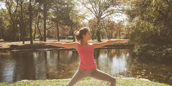年轻女子在靠近湖边的公园里做瑜伽练习 美丽的早秋 健康动力 — 图库照片