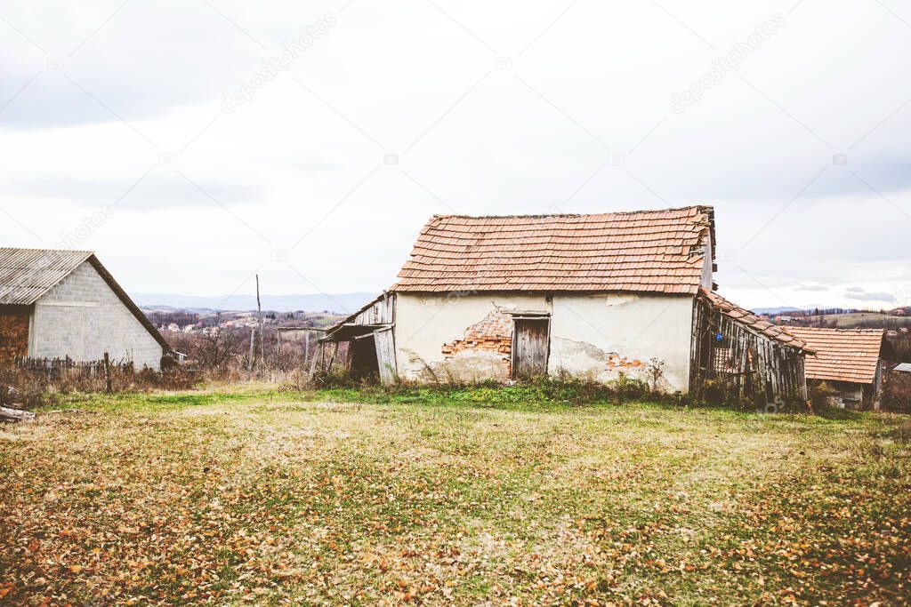 Rural house and farmland, countryside landscape, a village in Serbia, autumn cloudy day.