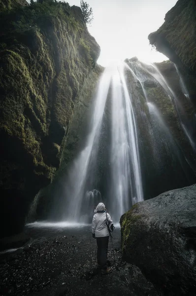 Mujer mirando la cascada de Gljufrabui dentro de una cueva en Icel — Foto de Stock