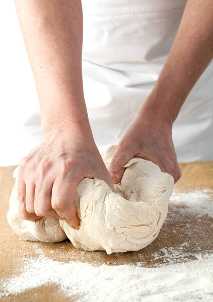Making dough by male hands at bakery