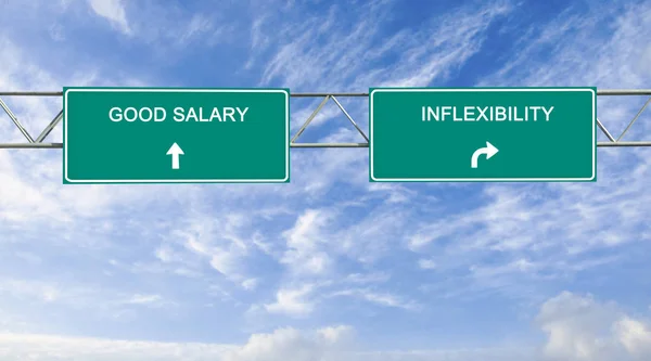 Señales de tráfico hacia un buen salario e inflexibilidad —  Fotos de Stock