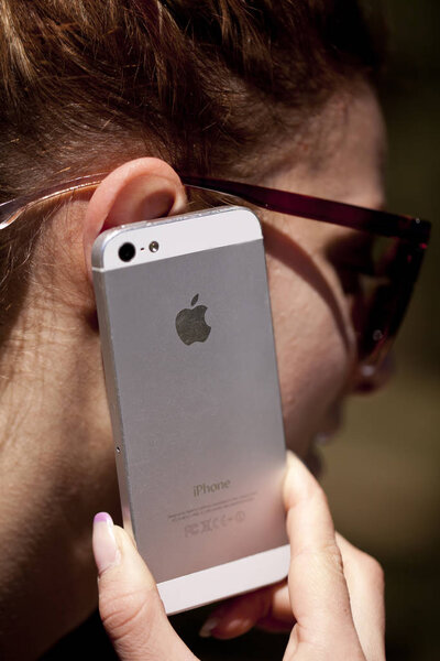 СОФИЯ, БУЛЬГАРИЯ - 17 апреля 2017 года: Женщина, разговаривающая со своим Iphone, продает телефон. iPhone был создан и разработан Apple inc
.