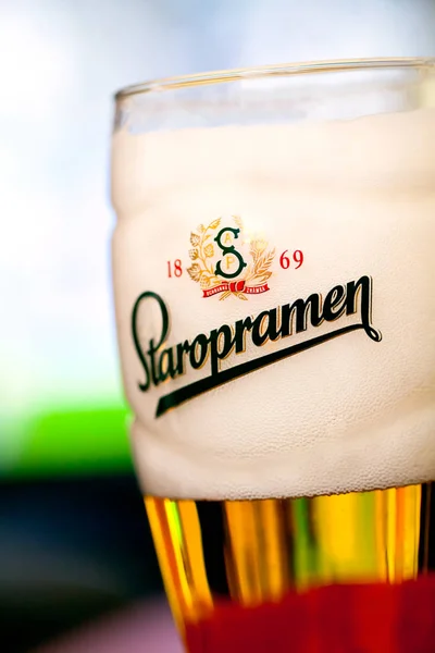 Sofia, Bułgaria - 08 maja 2017: Szkło Staropramen piwo premium na tle tv z odbicia. W 1869 w Praque założył browar Staropramen. — Zdjęcie stockowe