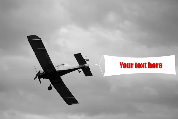 Vintage letadlo létat a zobrazovat reklamní cedule na obloze — Stock fotografie