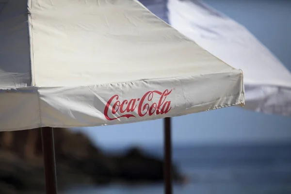 Sofie, Bulharsko - 24 září 2017: Coca-Cola text na umbrela poblíž pláže moře. Coca-Cola je světově největší prodejní sycených nealkoholických nápojů — Stock fotografie