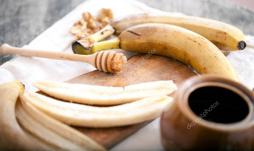 Banana slices on a plate with honey being poured onto them
