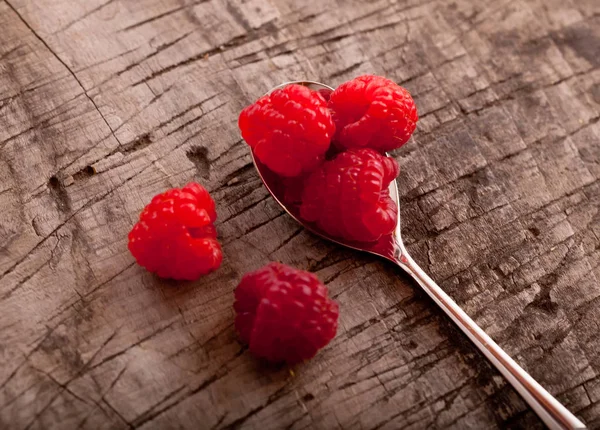 Macro raspberryes in small spoon, wooden background — Stock Photo, Image