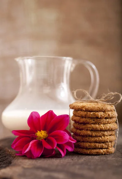 Biscuits et lait, petit déjeuner sur une vieille table en bois, fond alimentaire vertical — Photo