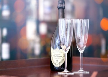 Sofya, Bulgaristan-29 Ekim 2017: Dom Perignon Vintage 2006 şampanya şişesi ve iki cam, ışıklar ve renkli Bar ışık bokeh