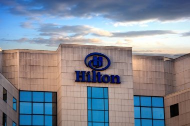 Sofya, Bulgaristan - 02 Kasım 2017: Hilton otelleri ve tatil köyleri logosu bina, gün batımı saati