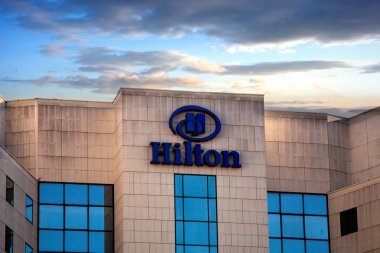 Sofya, Bulgaristan - 02 Kasım 2017: Hilton otelleri ve tatil köyleri logosu bina, gün batımı saati