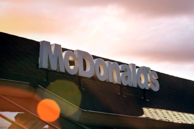 Sofya, Bulgaristan - 02 Kasım 2017: Kırmızı dramatik günbatımı gökyüzü arka plan üzerinde Mcdonalds logosu. Dünyanın en büyük fast food zinciridir, dünya çapında 31.000'den fazla restoran, her gün 58 milyon müşteriye hizmet vermektedir.