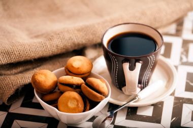 Ahşap masa kahverengi kahve Kupası ve tatlı bisquits gri