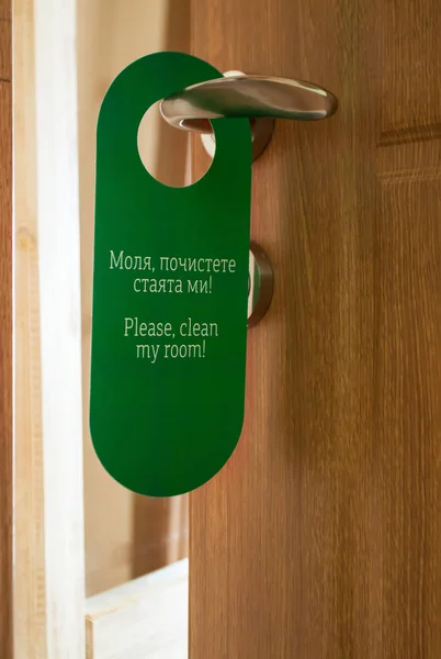 Hotel hanger sign, door knob. Do not disturb. Please clean up the room.