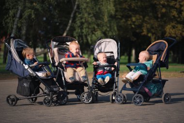 komik çocuk strollers parkta oturan