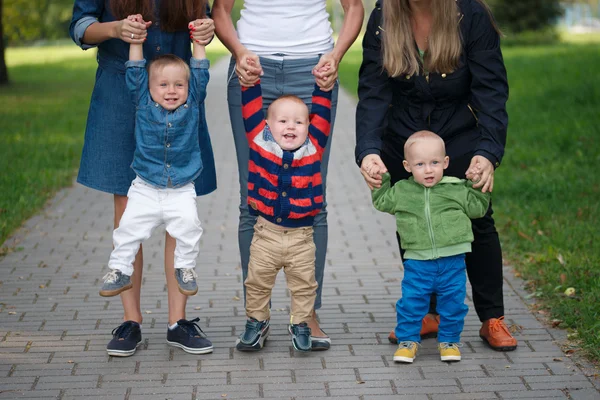 Mothers holding sons by hand — Stock Photo, Image