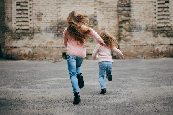 Duas meninas com cabelos longos fugindo — Fotografia de Stock