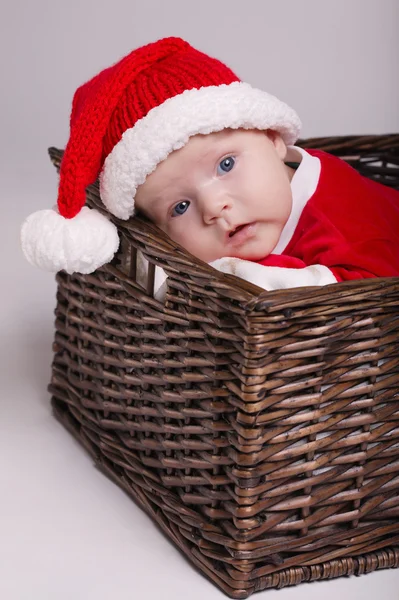 Bebê bonito com traje de Papai Noel deitado na cesta — Fotografia de Stock