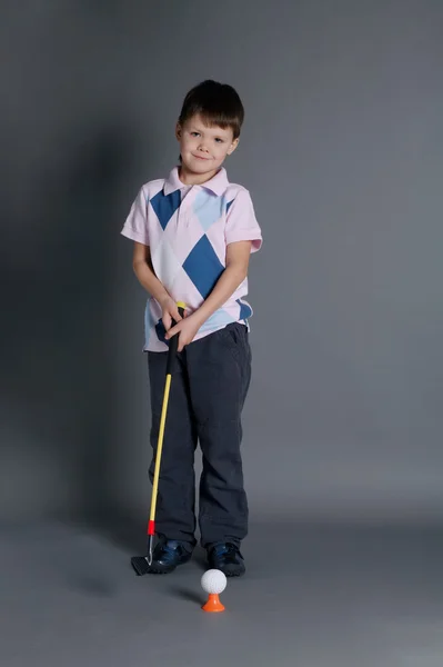 Menino joga mini golfe — Fotografia de Stock