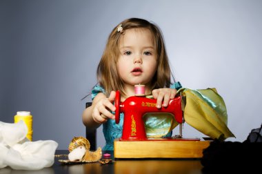 küçük kız dikiş makinesi ile oynuyor