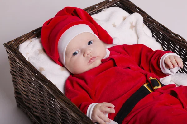 Bebê bonito com traje de Papai Noel deitado na cesta — Fotografia de Stock