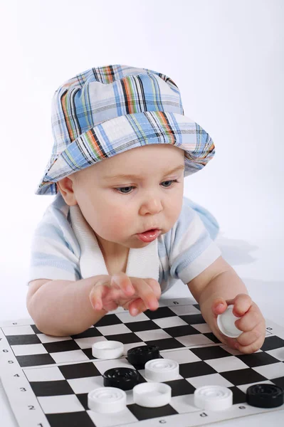 Μωρό παίζει πούλια σε λευκό — Φωτογραφία Αρχείου