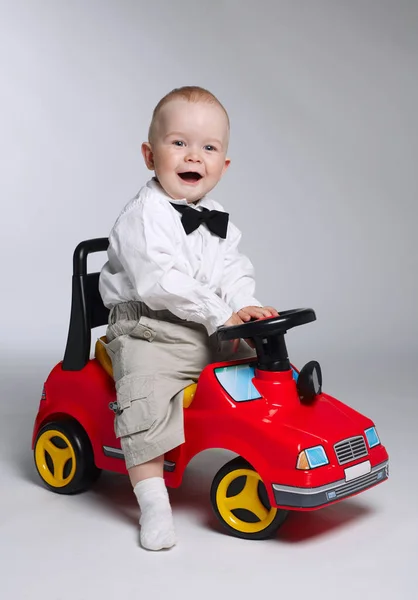 Маленький мальчик за рулем игрушечной машины — стоковое фото