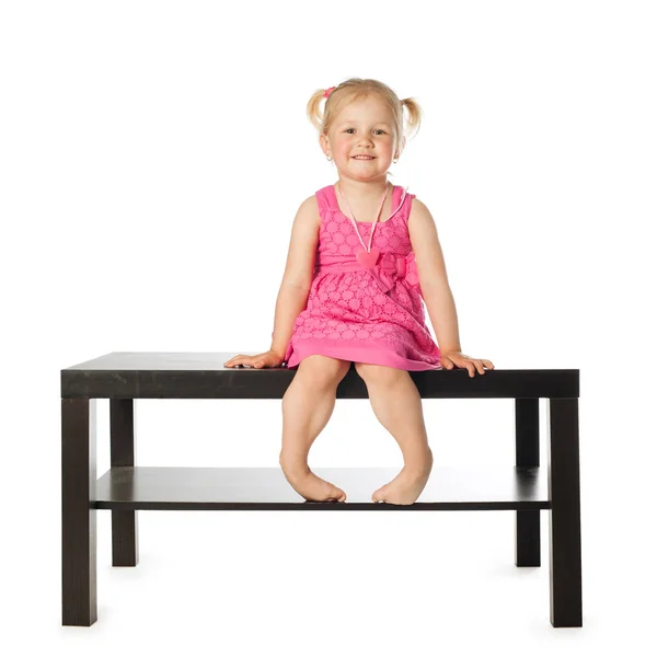 Kleines Mädchen auf dem Tisch isoliert — Stockfoto