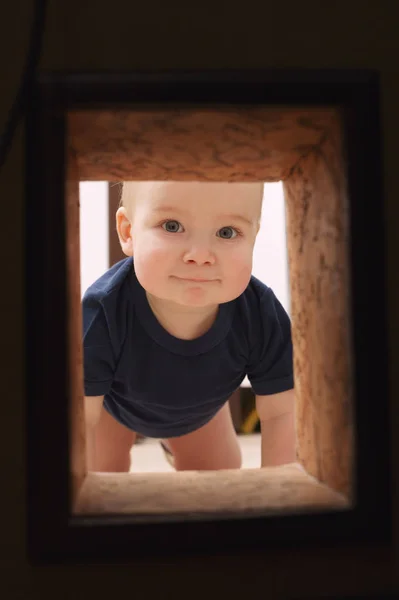 Little child looks to hole in the wall — Stock Photo, Image