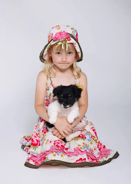 Маленька дівчинка з цуценям на білому — стокове фото