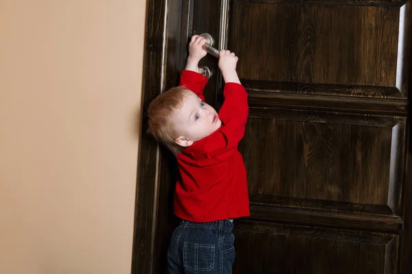 Menino tenta abrir a porta — Fotografia de Stock