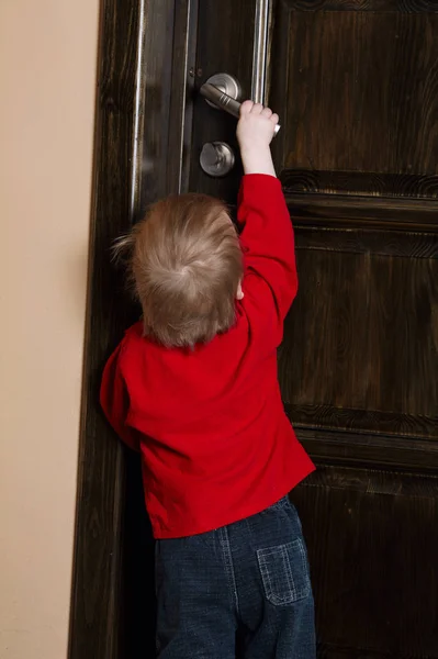 小男孩试图打开门 — 图库照片